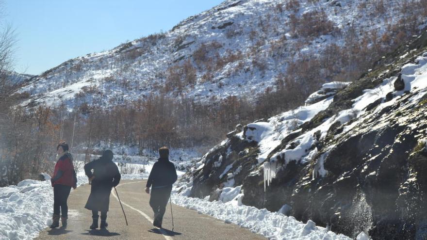 Vecinos de la Alta Sanabria transitan por una carretera entre la nieve