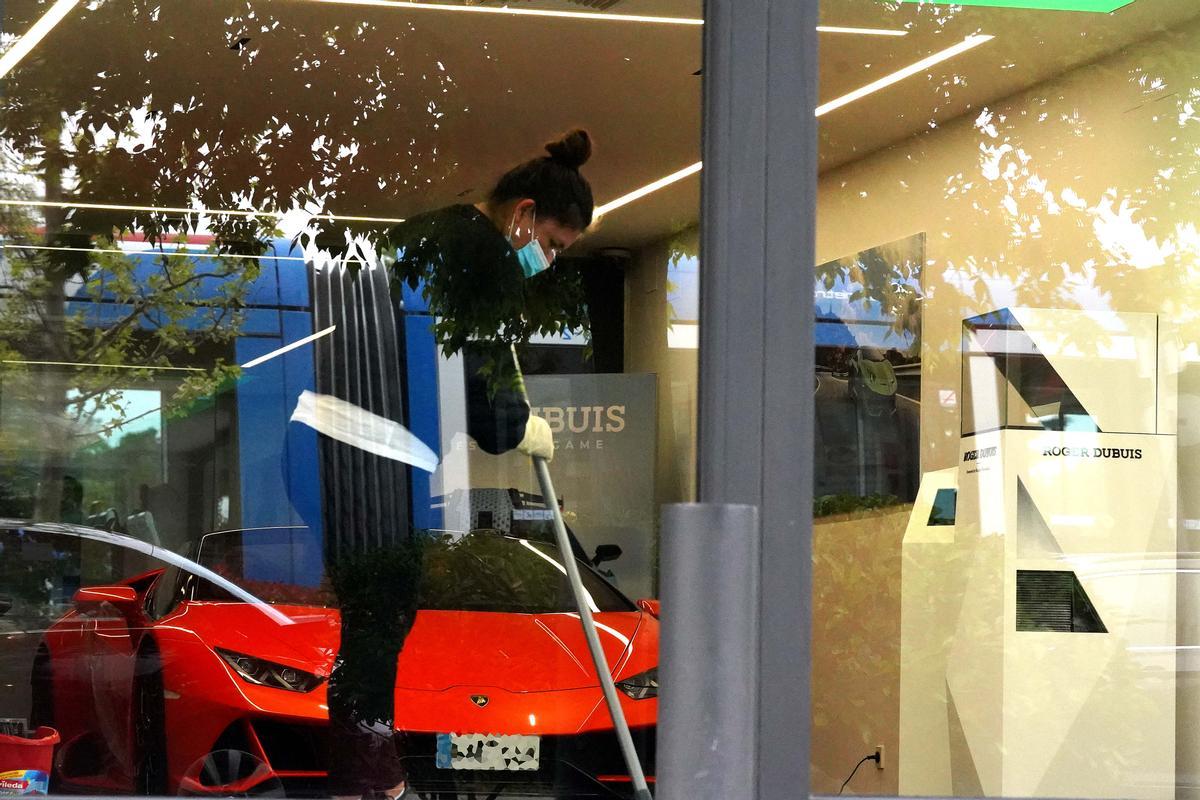 Una mujer limpia en el concesionario de Lamborghini de la localidad de Pozuelo de Alarcón.