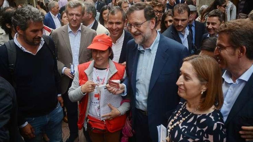 Una voluntaria de la Cruz Roja vende un décimo a Rajoy.