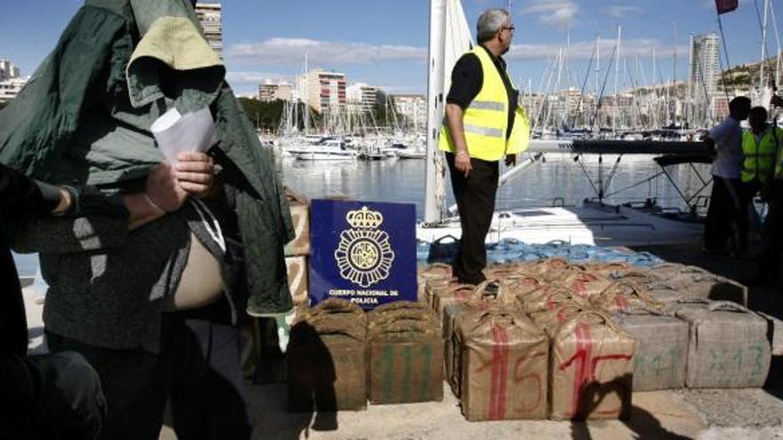 Uno de los detenidos junto a la droga interceptada.