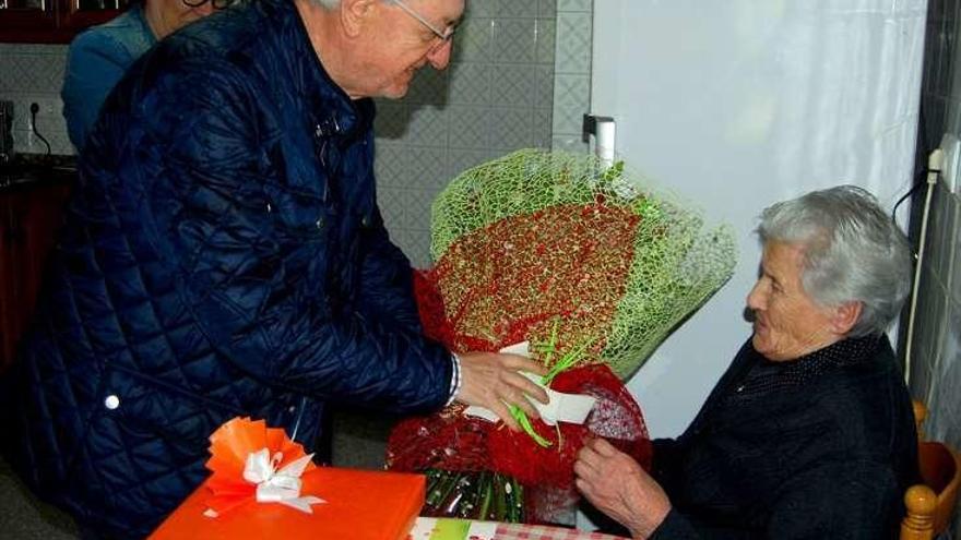 El alcalde entrega un ramo de flores a la cumpleañera. // FDV
