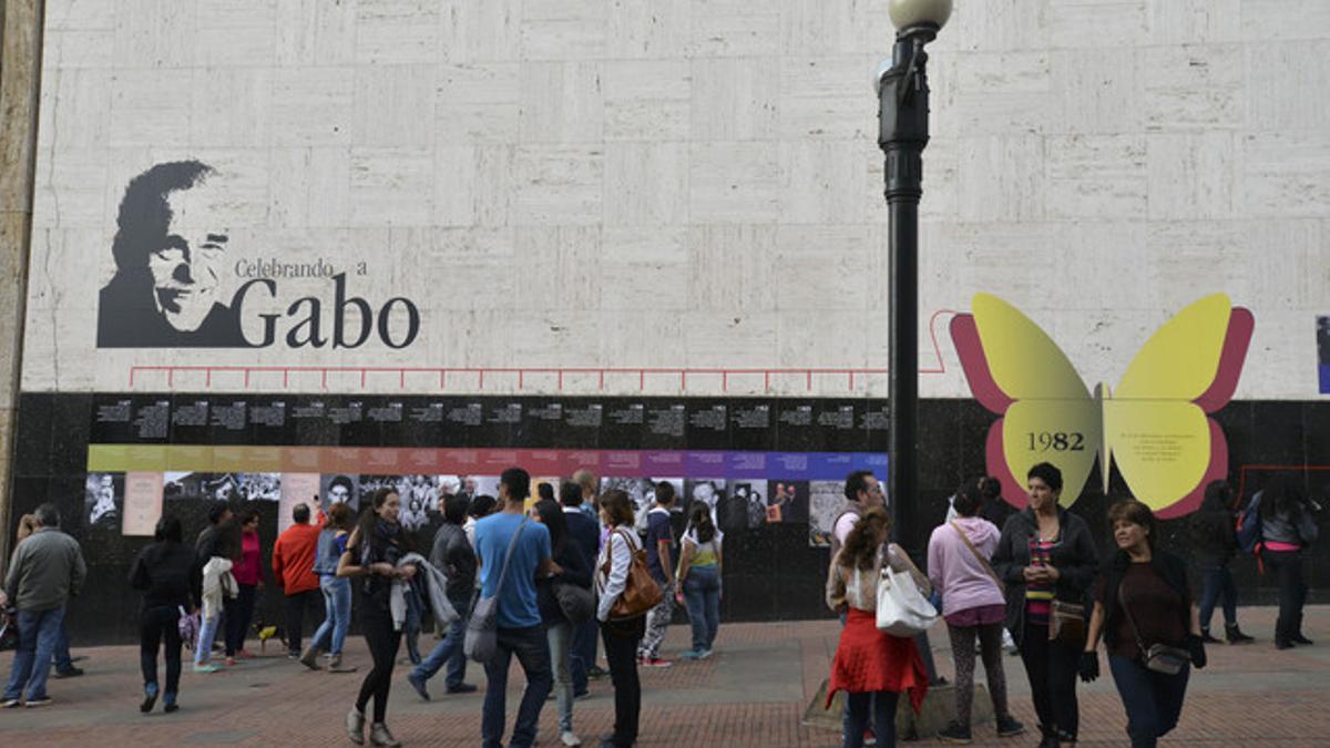 Decenas de personas, ante un mural que repasa la vida de García Márquez en una biblioteca de Bogotá.