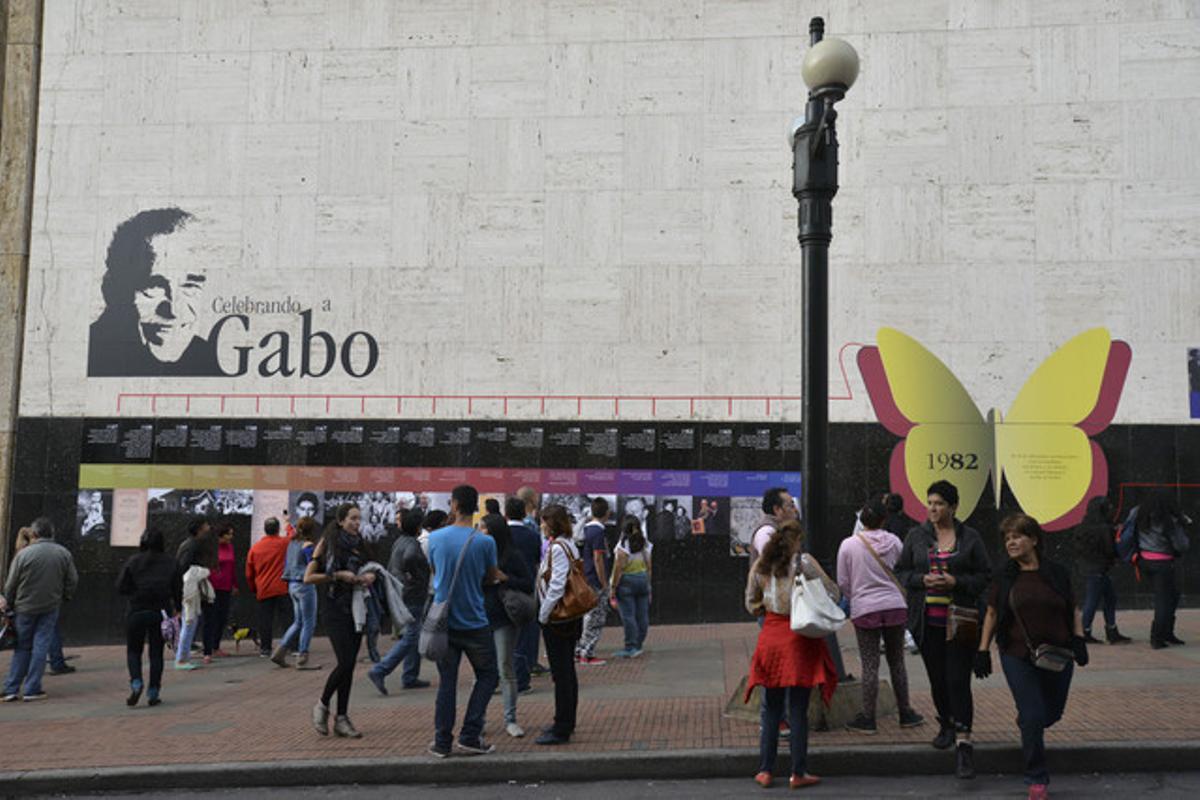 Desenes de persones, davant un mural que repassa la vida de García Márquez en una biblioteca de Bogotà.