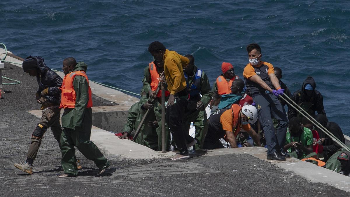 Migrantes bajando de un cayuco en El Hierro