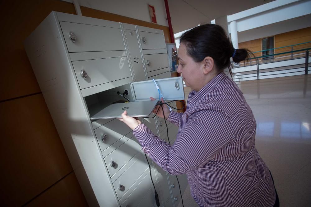 Alumnos usando las taquillas para cargar dispositivos