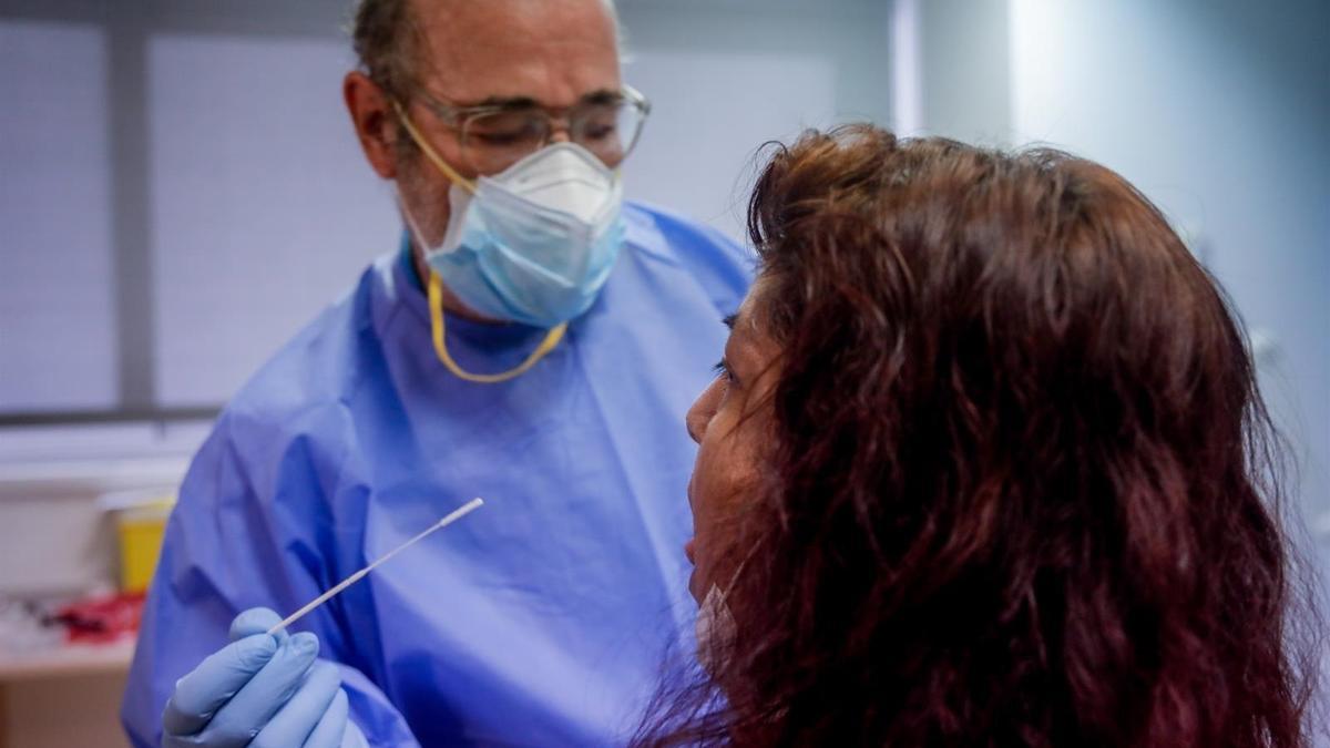 Un sanitario realiza una prueba de PCR a una paciente.