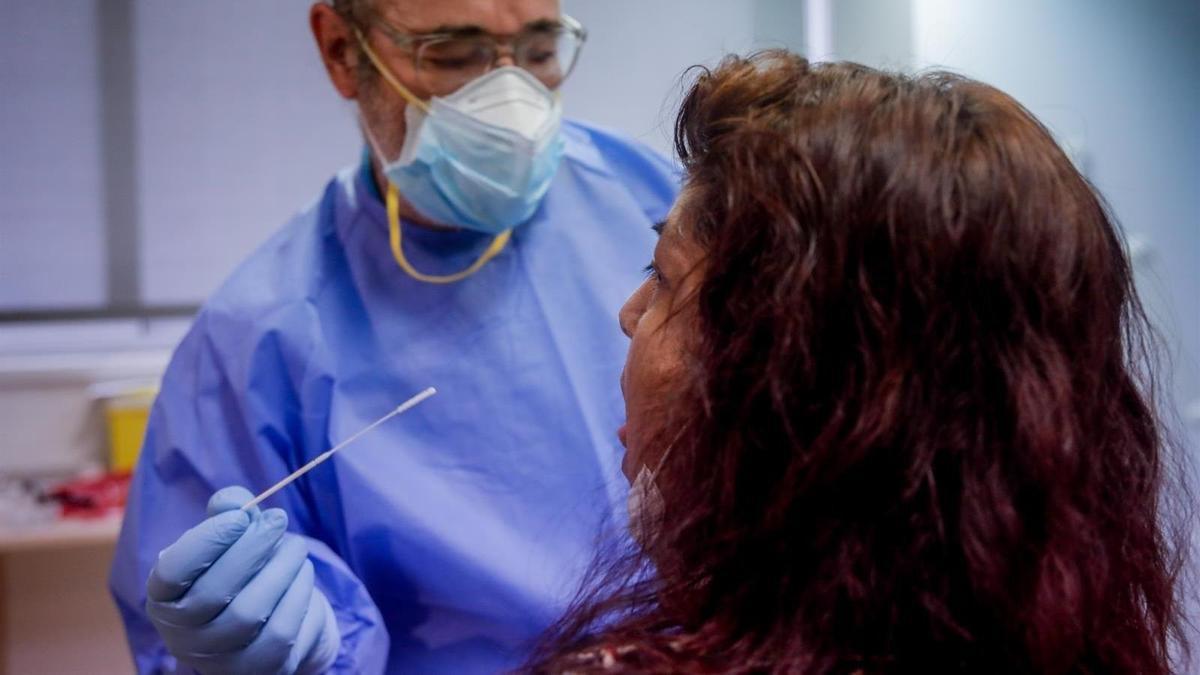 Un sanitario realiza una prueba de PCR a una paciente.