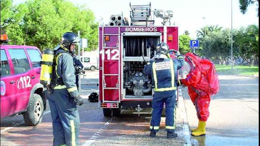 Los bomberos se preparan para entrar en el recinto de la piscina con trajes especiales