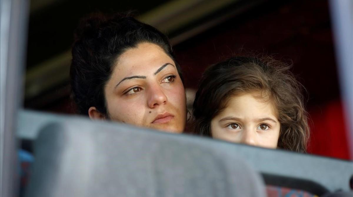 Una mujer con su hija en el autobús antes de salir de Idomeni.