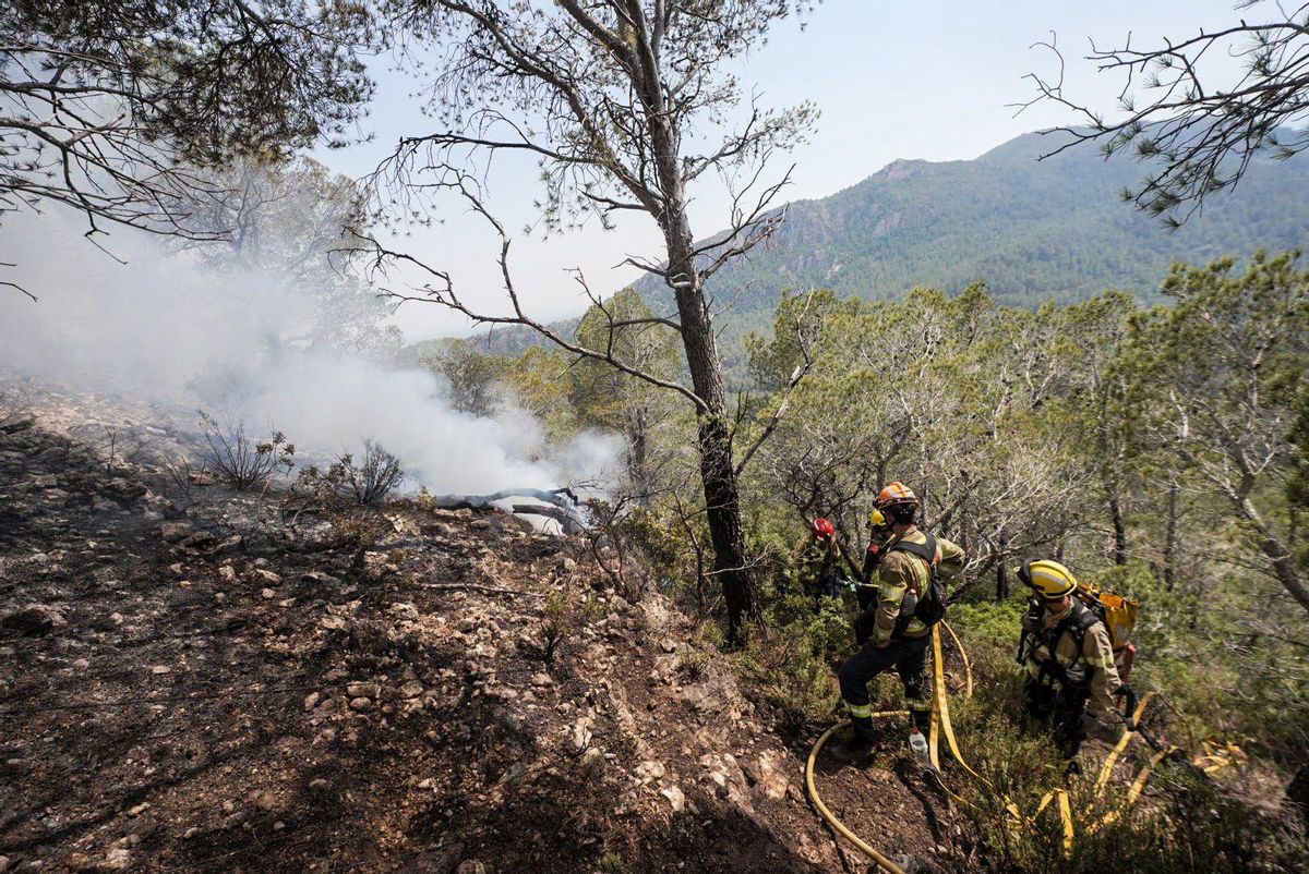 Fuego en Baix Ebre. Los bomberos trabajan en el incendio forestal en Paüls, Tarragona, este martes.