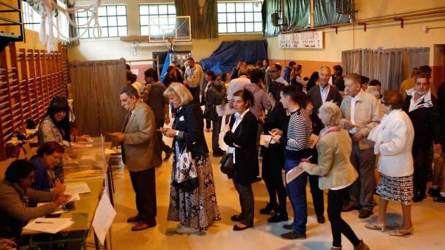 Un grupo de ciudadanos forma una fila para depositar su voto.