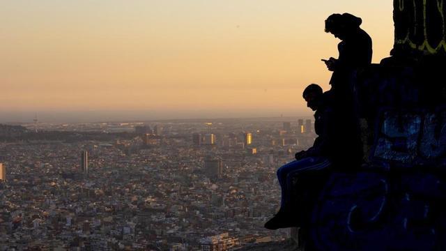 Dos joves al turó de la Rovira, davant una vista panoràmica de la ciutat de Barcelona. | FERRAN NADEU