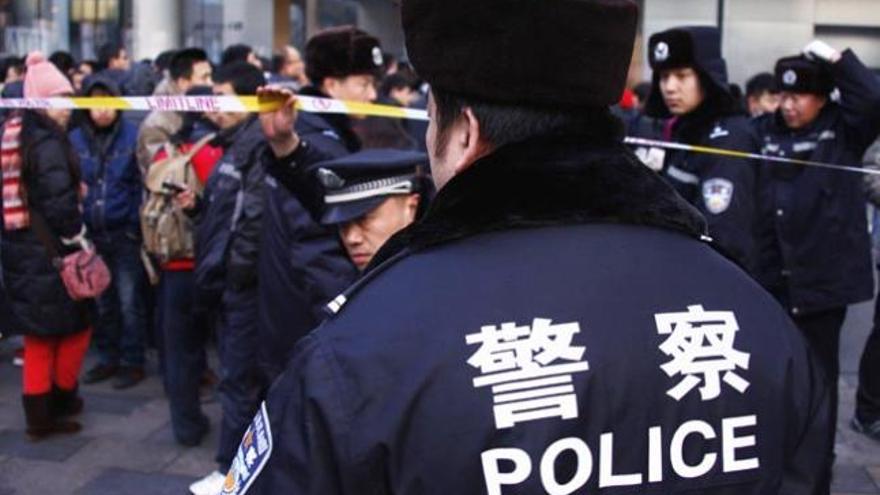 Varios policias chinos delante de una tienda de Apple.