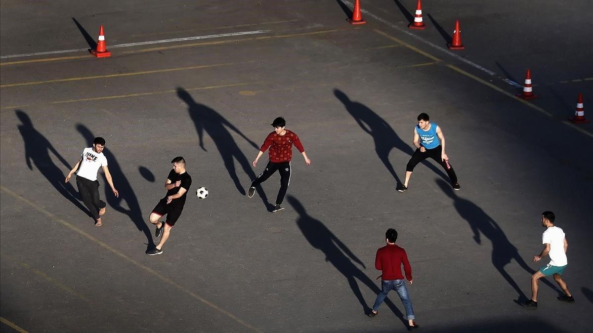 Varios jóvenes juegan a fútbol en una escuela de conducción cerrada al público