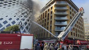 Los bomberos extinguen las llamas en el edificio de Zaha Hadid. 