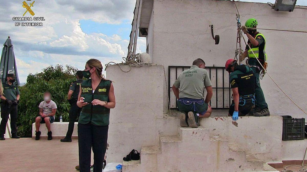 El Tuvi, a la izquierda, sentado, mientras uno de los buzos inicia el descenso en busca del cuerpo.