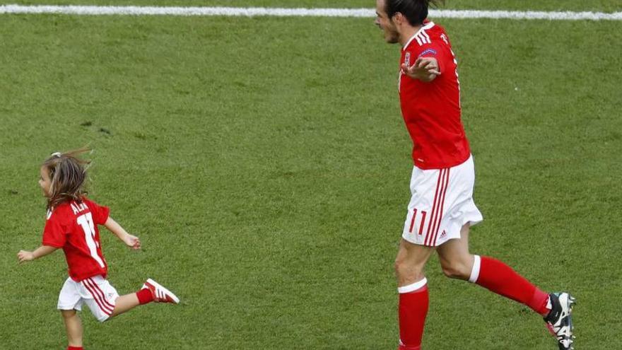 Gareth Bale, elegido el mejor jugador del partido, celebra sobre el césped con su hija la clasificación de Gales.