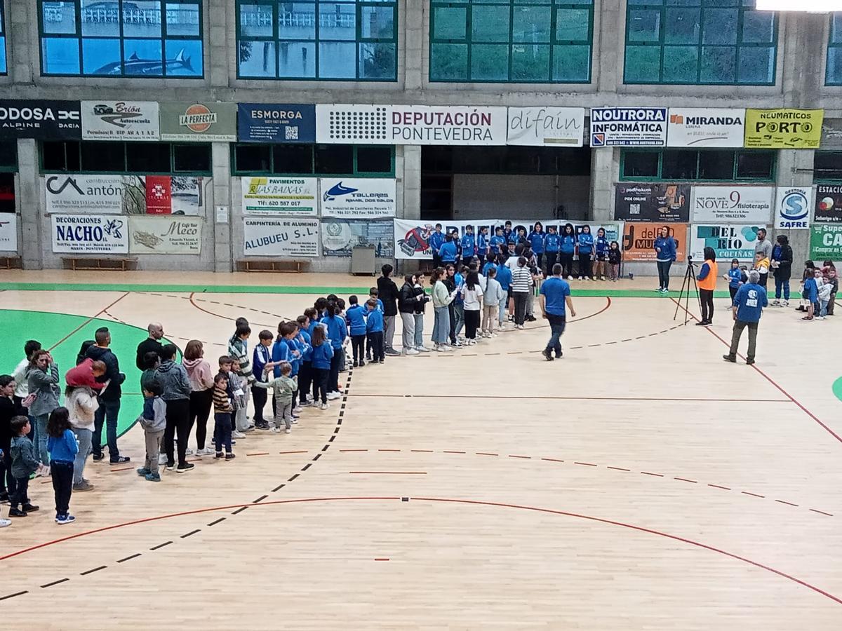 Los niños en fila sobre la pista del pabellón de Bueu para depositar su voto para pedir pediatras.