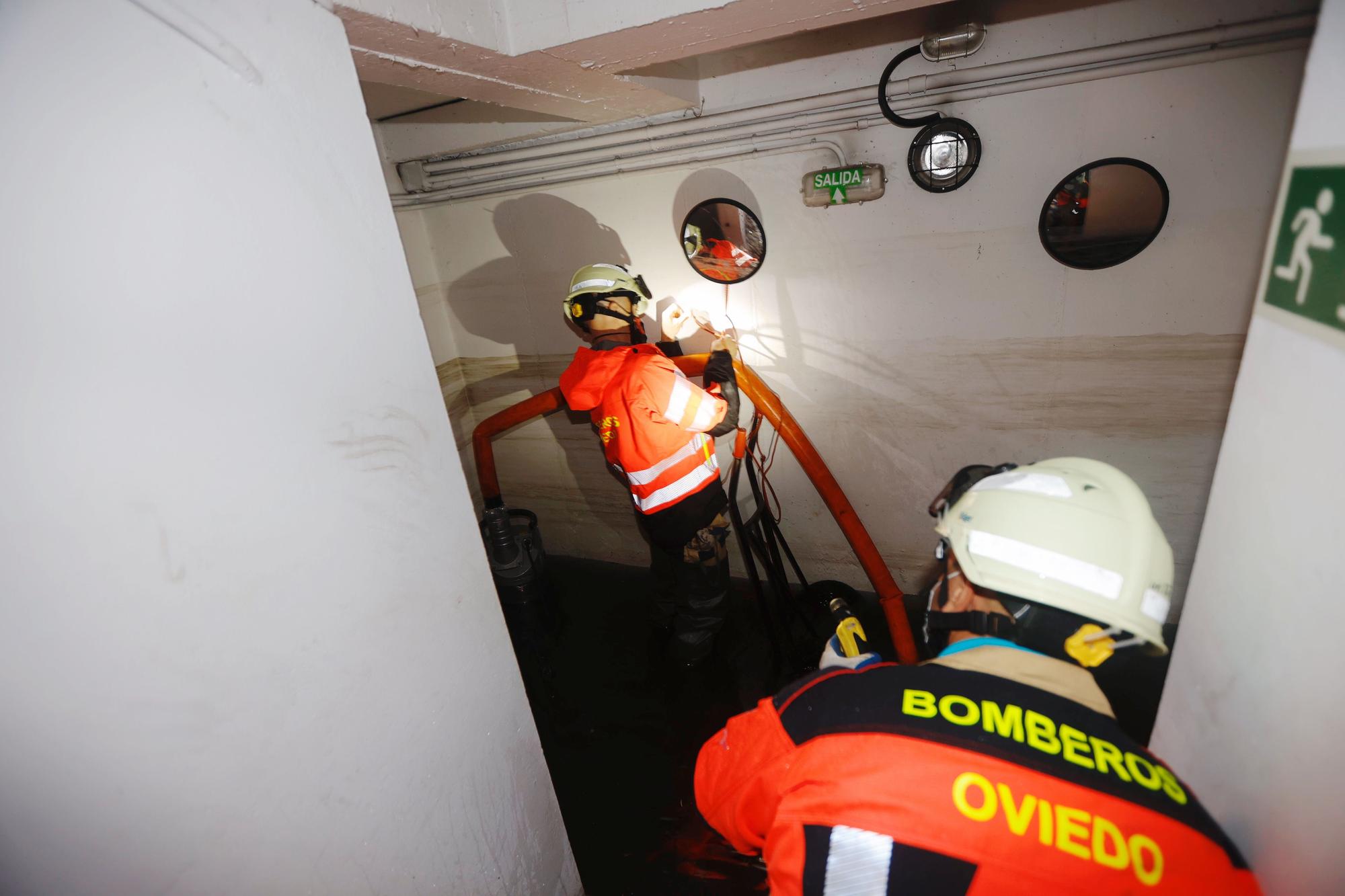 Bomberos interviniendo en garajes inundados de Oviedo.