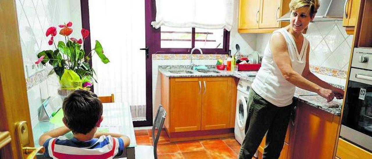 Concha Mora Marqués charla con su hijo Carles en la cocina, al que tuvo gracias a la técnica de fecundación «in vitro». |