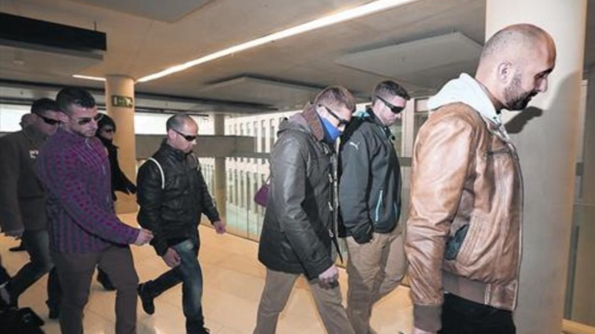 Un grupo de mossos acompañan a uno de los imputados, en la Ciutat de la Justícia.
