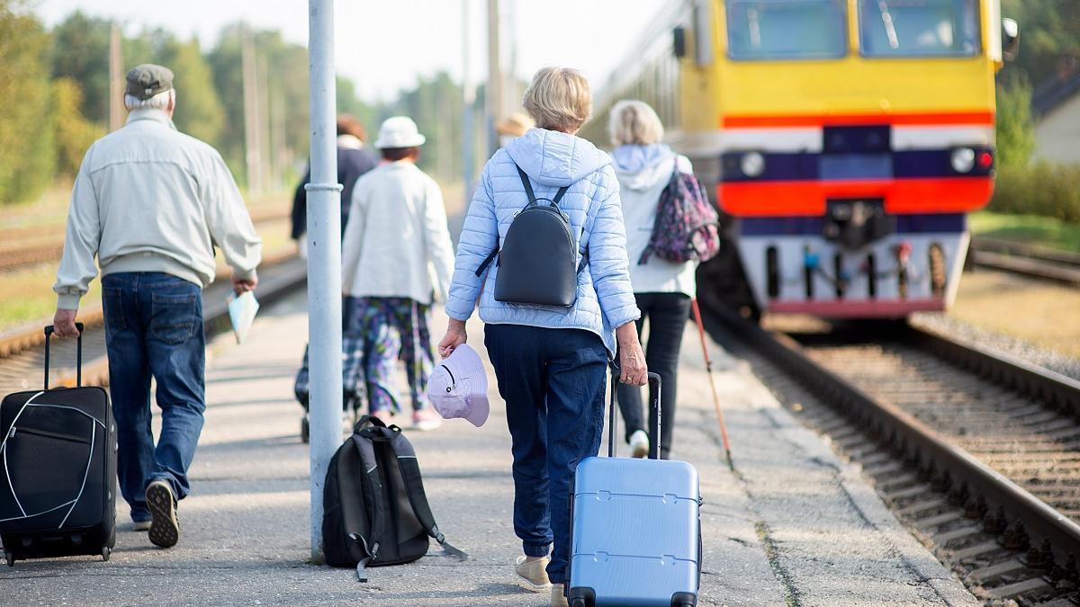 Un grupo de personas mayores, cogiendo un tren.