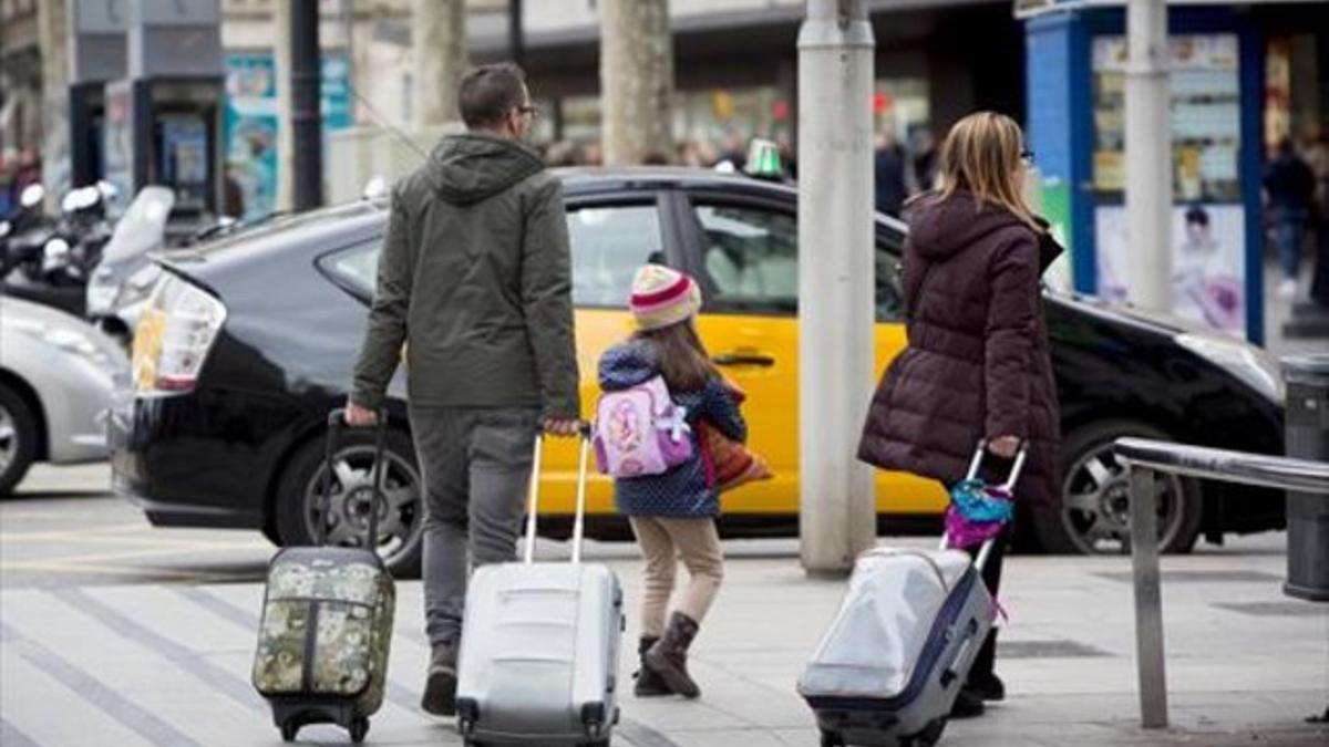 Unos turistas se dirigen a una parada de taxis en Barcelona.