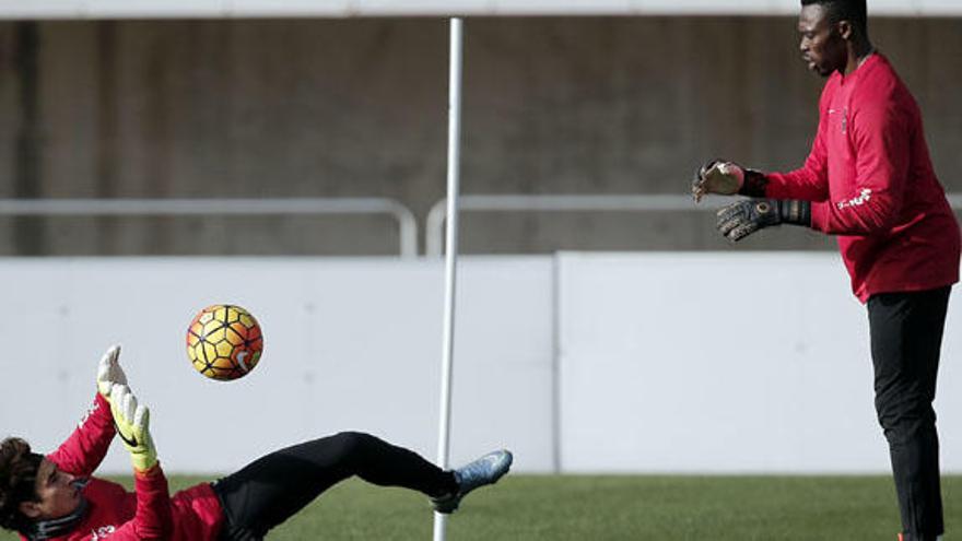 Guillermo Ochoa realiza ejercicios junto a Carlos Kameni, ayer durante el entrenamiento del Málaga CF.