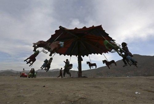 Afghan children play on a swing at an old part of Kabul