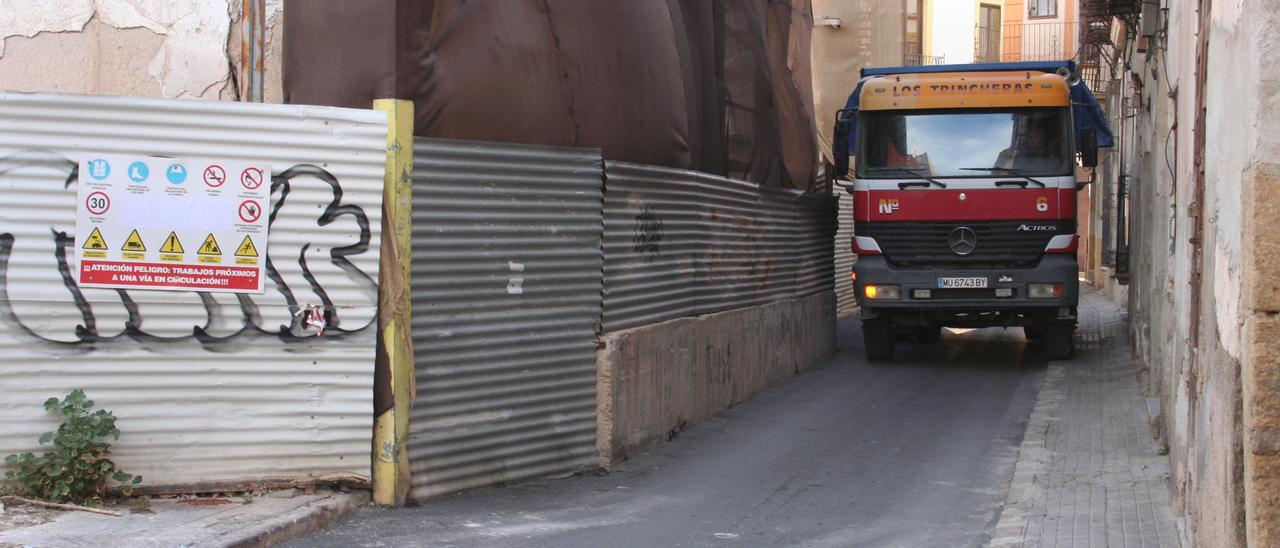 El andamio de la calle Selgas obliga a un camión a subirse a la acera, este miércoles.