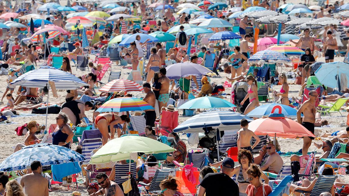 Una playa abarrotada de gente.