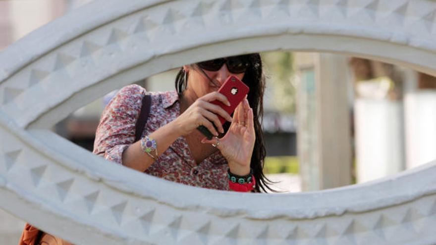 Una joven utiliza las redes sociales desde su móvil.