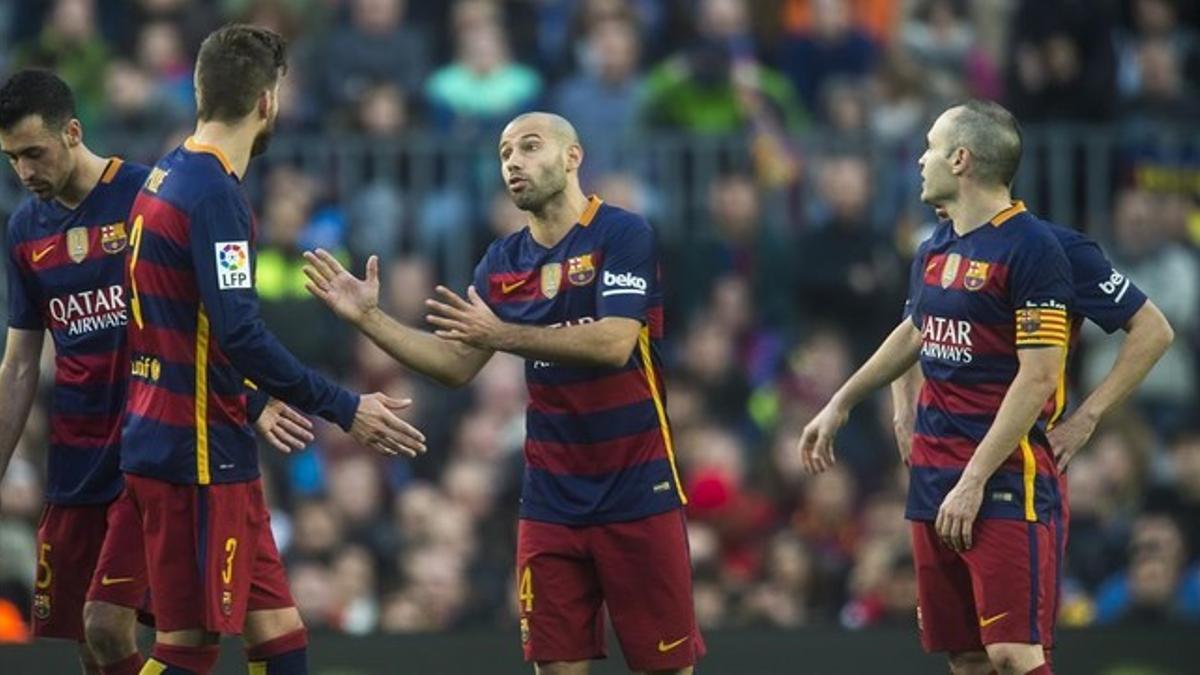 Mascherano, Iniesta y Piqué conversan durante el Barça-Atlético en el Camp Nou.