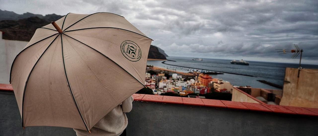 Una mujer se resguarda de la lluvia en Santa Cruz de Tenerife.