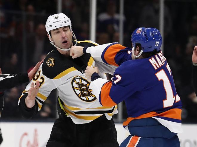 Zdeno Chara # 33 de los Boston Bruins pelea con Matt Martin # 17 de los New York Islanders durante su partido en el Nassau Coliseum de NYCB Live.