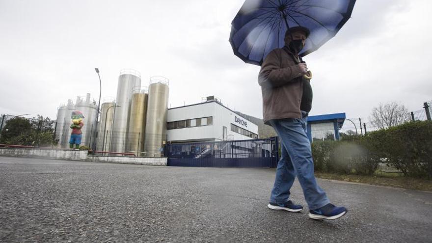 Un hombre pasea ante la fábrica de Danone en Salas. | Miki López