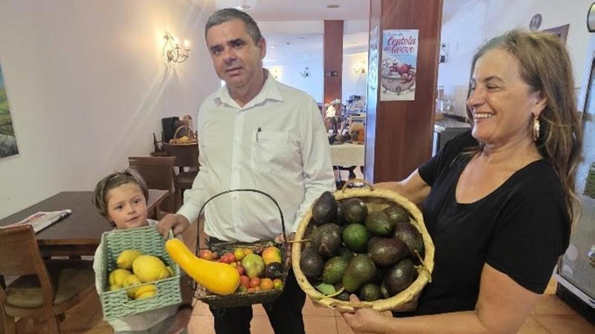 Pablo Agrelo, Isabel Castro y su nieto muestran algunos de los productos de su huerta.
