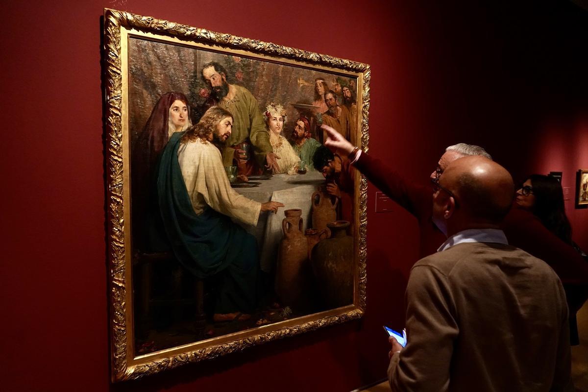 Mariano Vergara explica un detalle de 'Las bodas de Canaán' de Antonio Estruch, en la exposición 'Vino. Arte y símbolo'.