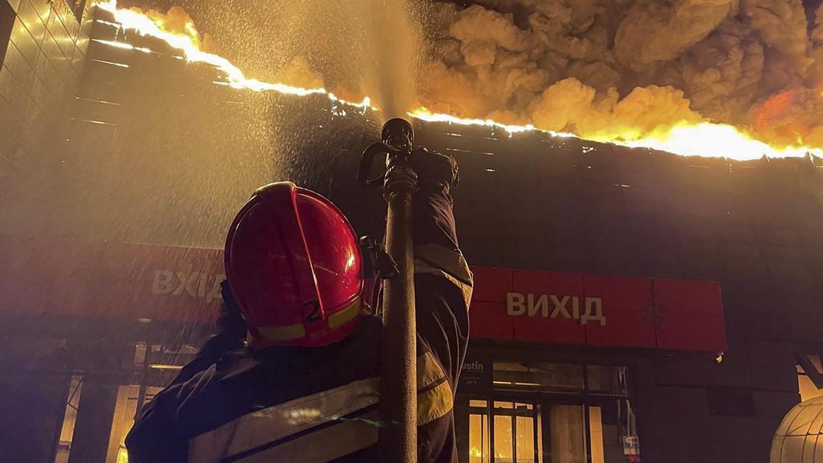 Los bomberos tratan de apagar las llamas del hipermercado afectado por el ataque