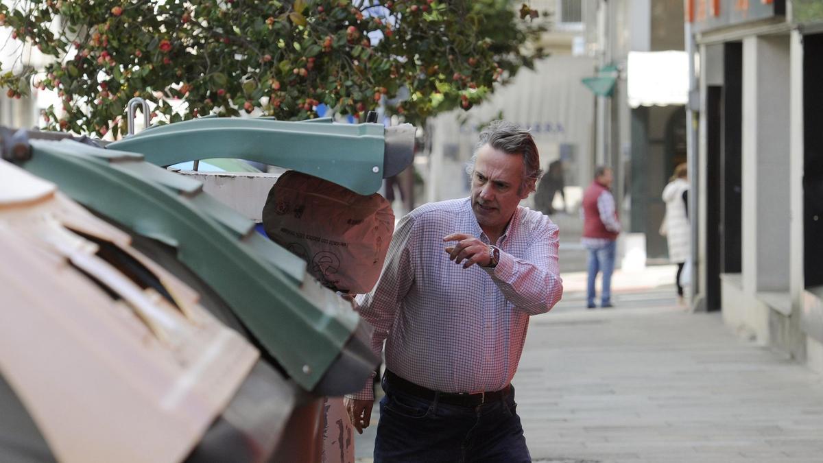 Un varón tira una bolsa de basura en una céntrica calle de Lalín (Pontevedra).