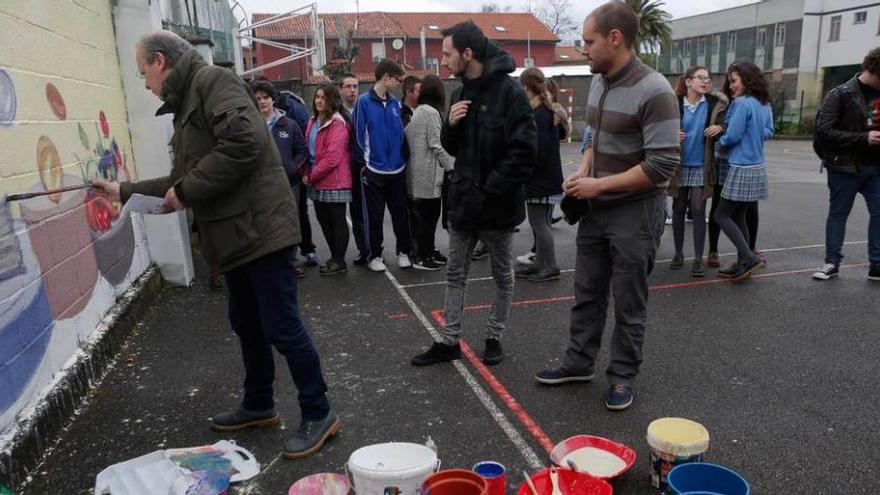 Favila realiza el mural en el patio del colegio Luisa de Marillac ante la mirada de Samuel Armas, Nacho Riestra y un grupo de alumnos.