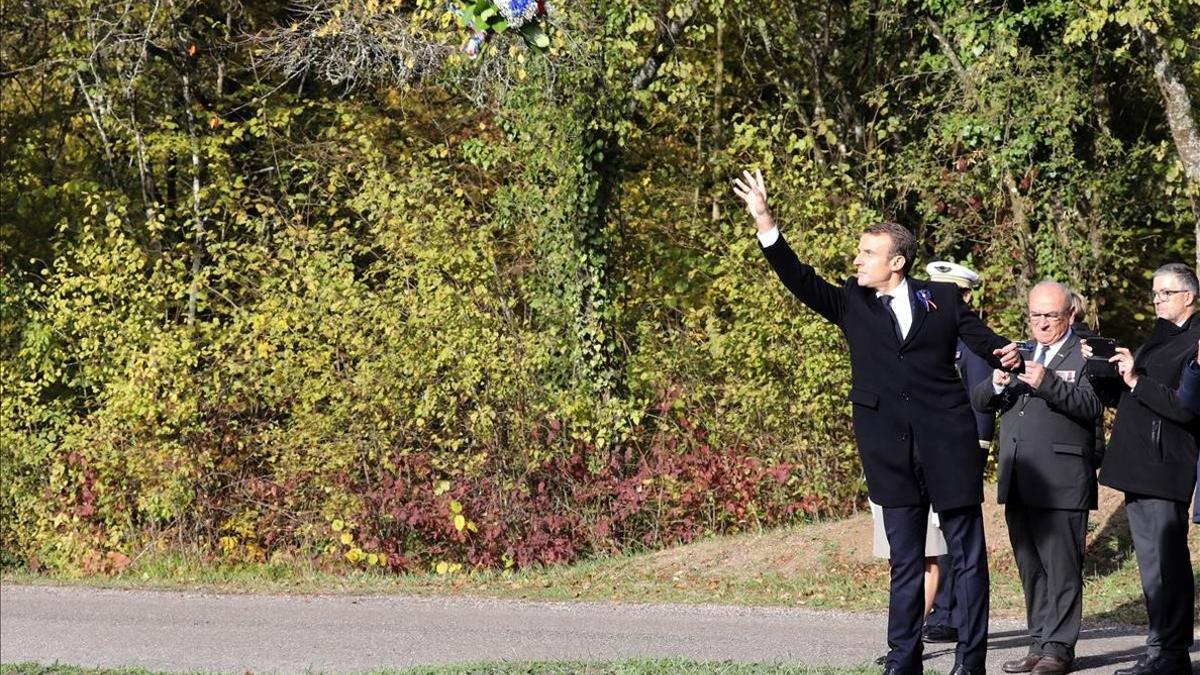 Macron lanza un ramo de flores durante la ceremonia en Les Entonnoirs.