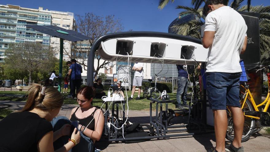 El apagón obliga a muchos vecinos a cargar sus móviles en las pérgolas solares instaladas en València