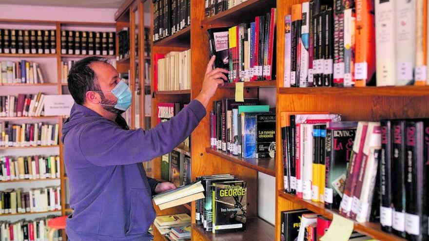 El encargado de la Biblioteca de Moraleja, Rafa Miguel, ordena los libros en las estanterías | |  EMILIO FRAILE