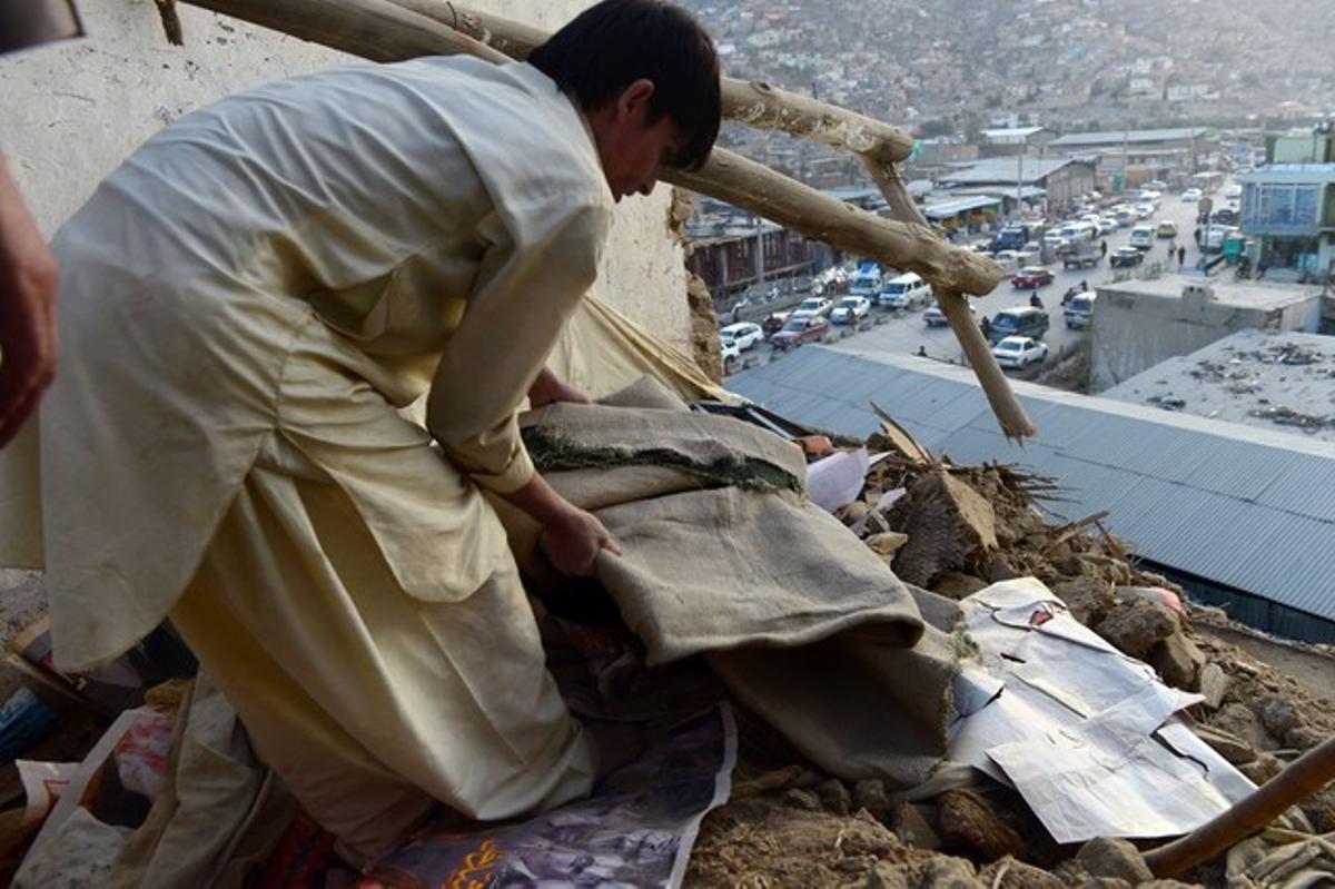 Un hombre mueve los escombros de su vivienda en Kabul, que se derrumbó a causa del terremoto.