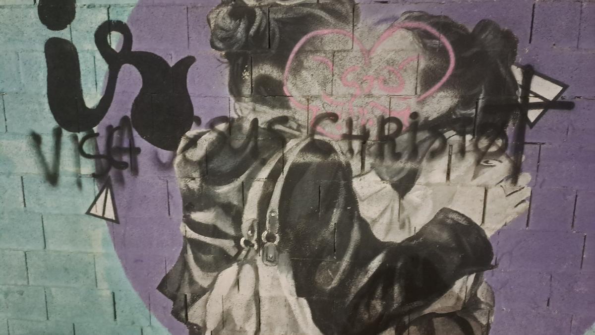 Pintadas con esprai sobre la cara de las dos chicas besándose en el mural de Gandia