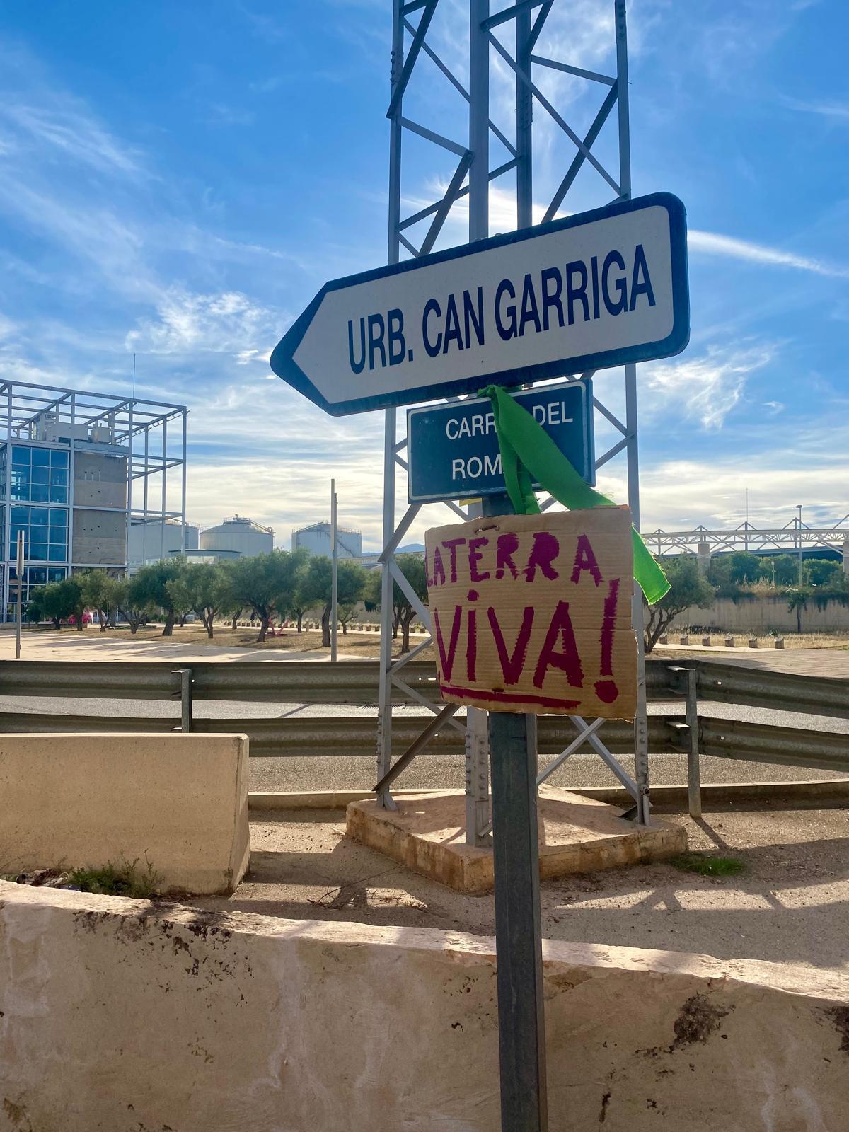 Un cartel de protesta junto a la señalización que indica la ubicación del núcleo residencial.