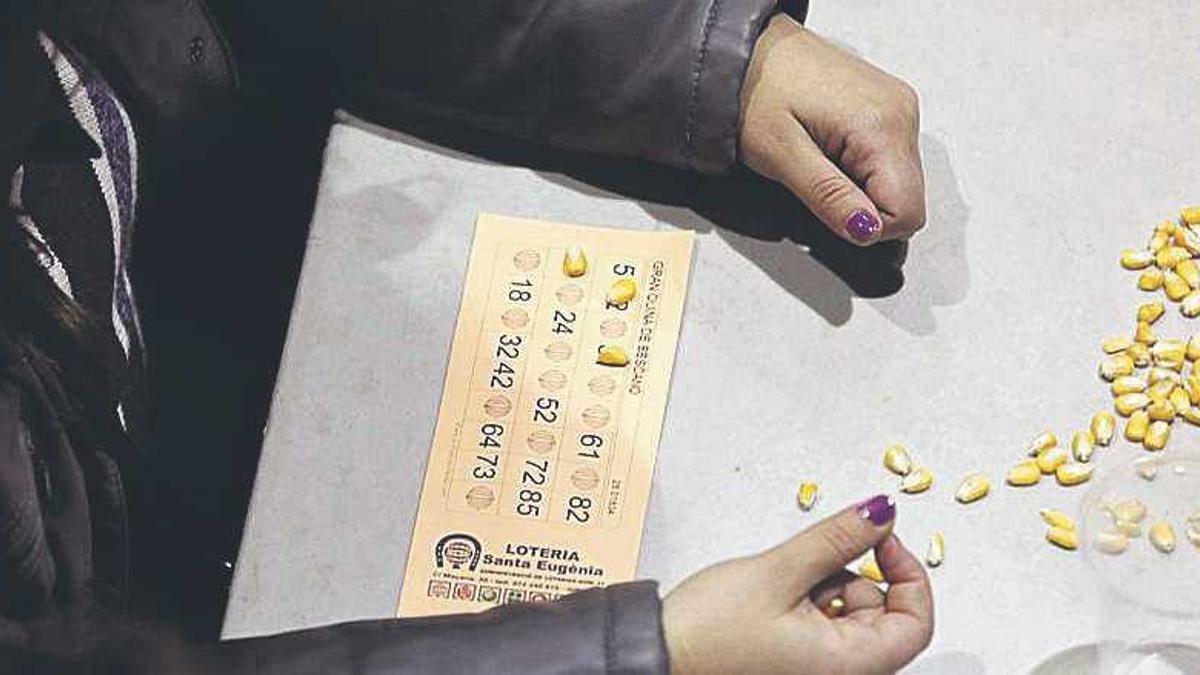 Una dona marcant els números del cartró amb blat de moro.