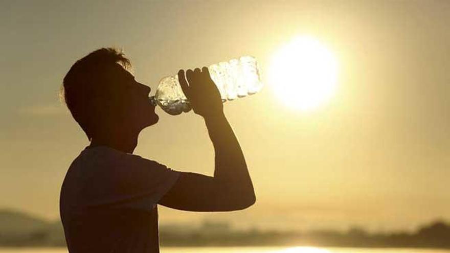 Un joven bebe agua para hidratarse en una de las anteriores olas de calor.