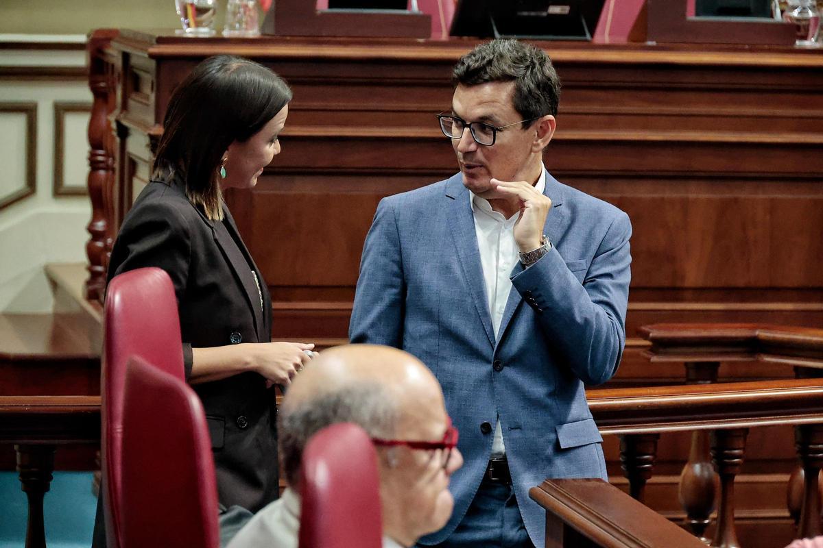 El consejero Pablo Rodríguez conversa con la diputada del PP Jennifer Curbelo antes de la sesión plenaria.